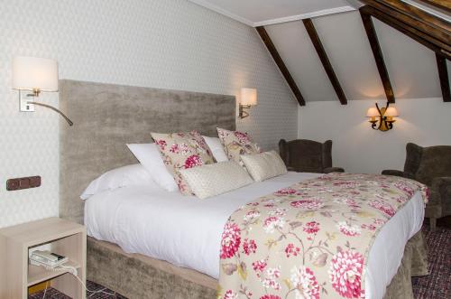 a bedroom with a large bed and two chairs at Hotel Presa in Riaño