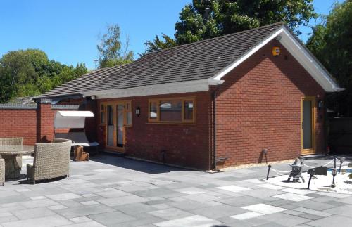 a small red brick building with a patio at Orchid House in Southport