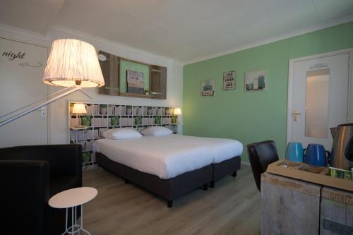 a bedroom with a bed and a table and chairs at Carré Hotel Zuid-Limburg in Hulsberg