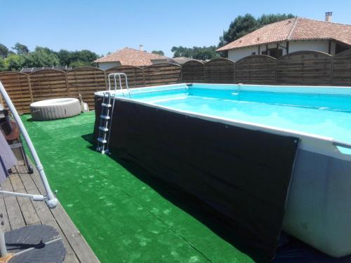une piscine entourée d'herbe verte dans l'établissement villa lou miquéou, à Lit-et-Mixe