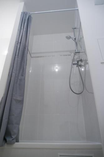 une salle de bain avec une douche avec un rideau de douche dans l'établissement BtoBed - Location Professionnelle - Studio Confort Parking Gratuit Villepinte - Proche Parc des Expositions et Aéroport CDG, à Villepinte