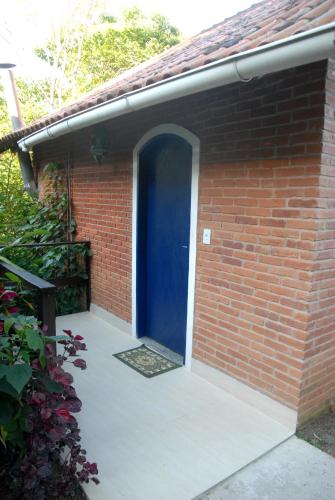 a brick building with a blue door on it at Pousada Mirante do Penedo in Penedo