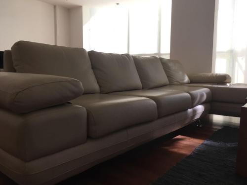 a leather couch in a living room with a window at Apart Edificio Clever in La Plata