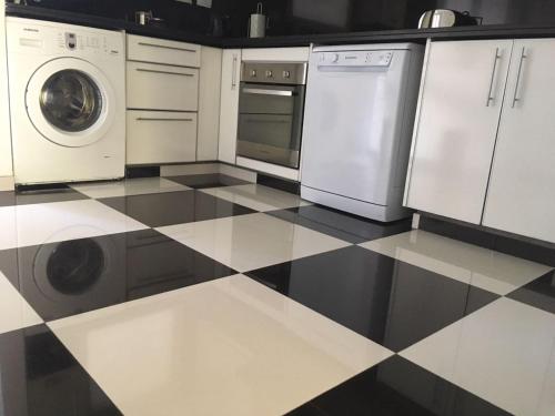 a kitchen with a black and white checkered floor at Apart Edificio Clever in La Plata