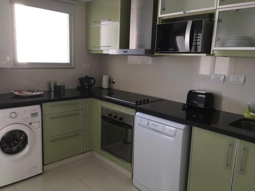 a kitchen with a washing machine and a washer at Apart Edificio Clever in La Plata