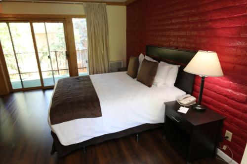 a bedroom with a large bed with a red wall at North Lake Lodges & Villas in Incline Village