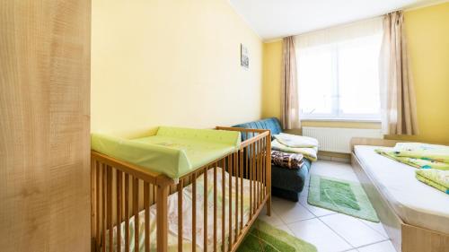 a baby room with a crib and a couch at Villa Malva in Karwia
