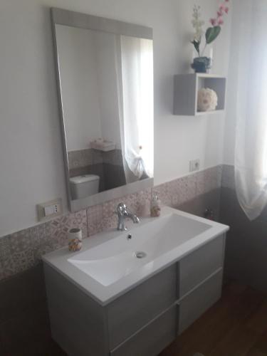 a bathroom with a white sink and a mirror at Casa Belvedere in Agrigento