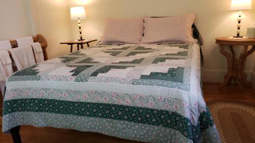 a bedroom with a bed with a quilt on it at Hawks House Inn in Walpole