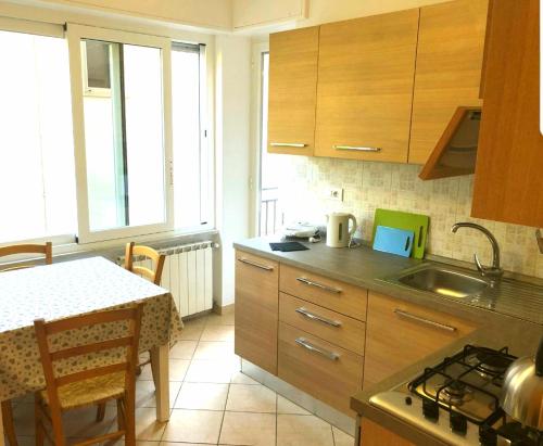 Il comprend une cuisine équipée d'un évier et d'une table avec une cuisinière. dans l'établissement Monterosso - Apartment, à Monterosso al Mare