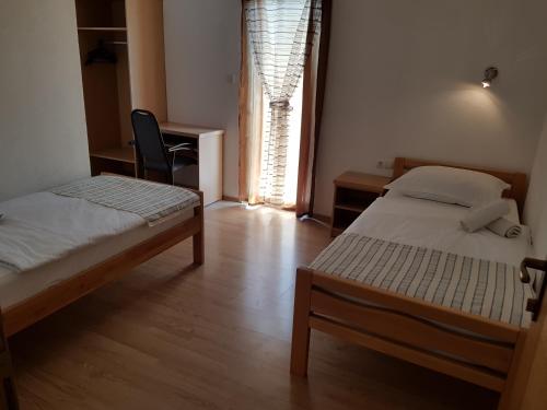 a bedroom with two beds and a window at Pansion Bojic in Međugorje