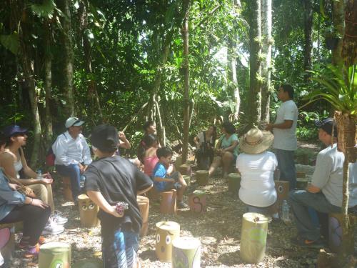 a group of people sitting around in the forest at Hospedaje Las Amazonas in Iquitos