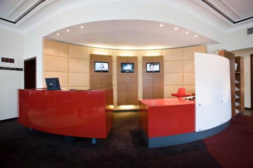 an office with a red desk with a computer on it at Hotel Gräfrather Hof in Solingen