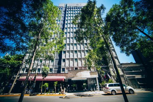 a car parked in front of a tall building at LaiLa Hotel CDMX Reforma in Mexico City