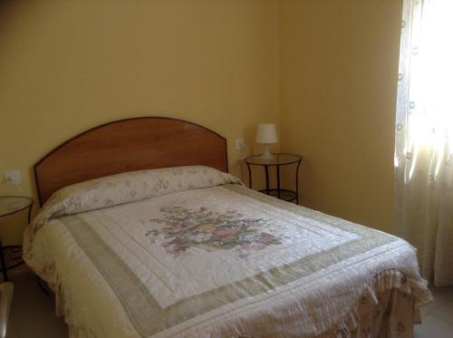 a bedroom with a bed with a floral quilt on it at La torre in Rodonyà