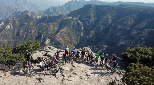 a group of people riding bikes on the edge of a mountain at Hotel Mansion Tarahumara in Areponapuchi