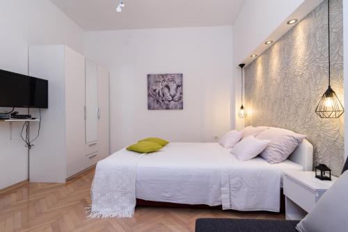 biała sypialnia z białym łóżkiem i telewizorem w obiekcie Apartment Sara w Trogirze