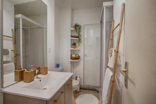 een witte badkamer met een wastafel en een toilet bij Studio Cosy + Hyper-centre + Netflix in Saint Lo