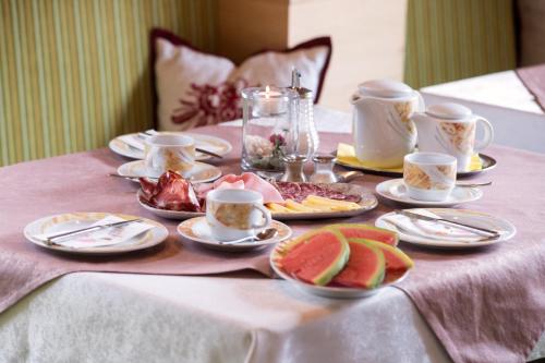 a table with cups and plates of food on it at Pension Alpengruss in Gerlos