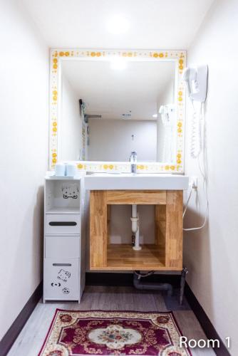 a bathroom with a sink and a mirror at Gwawa Hotel in Kaohsiung