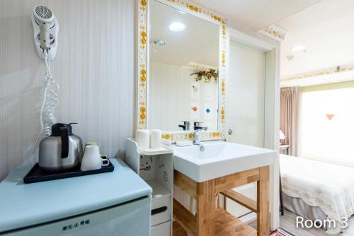 a bathroom with a sink and a mirror at Gwawa Hotel in Kaohsiung