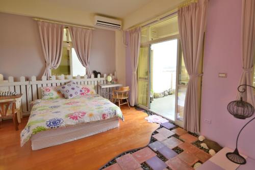 a bedroom with a bed and a large window at Happiness Factory in Huxi