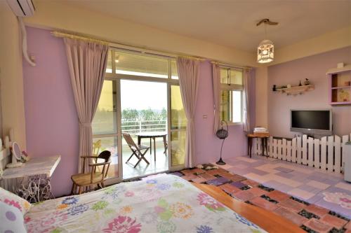 a bedroom with a bed and a balcony at Happiness Factory in Huxi