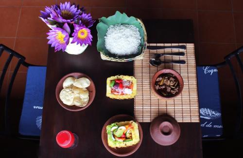 a table with plates of food and flowers on it at Blue Pillars Kandy in Kandy