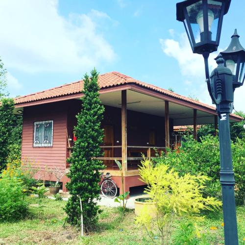 a house with a porch and a street light at Baan Suan Kru Kob in Ban Ko Maphang