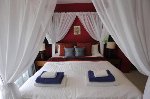 Bann Jai Dee في شاطئ ناي يانغ: غرفة نوم بسرير ابيض كبير عليها مناشف زرقاء