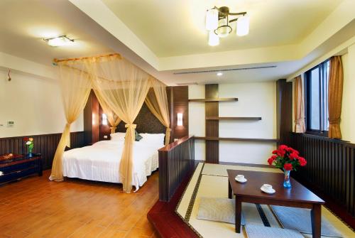 a bedroom with a bed and a table with flowers at Ming Lu Holiday Hotel in Renai