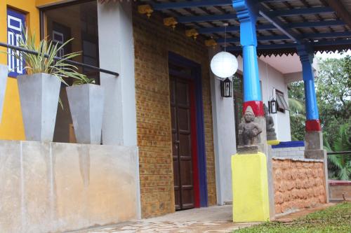 a building with colorful columns and a door with a statue at Blue Pillars Kandy in Kandy