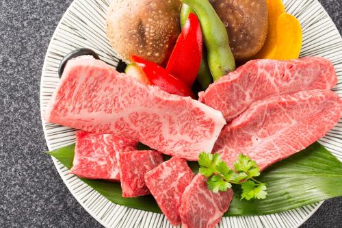 a plate of meat and vegetables and a hamburger at Koyado Enn in Toyooka