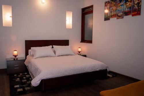 a bedroom with a bed with two lamps on it at Hospederia Flor de la Villa Real in Villa de Leyva