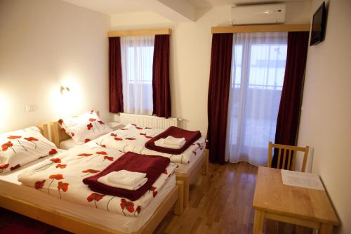 a hotel room with two beds and a table at Pansion Budimir in Đakovo