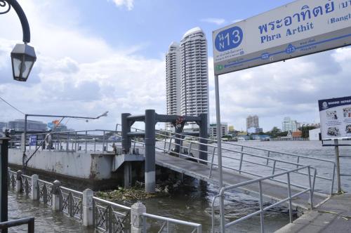 a street sign next to a river with a building at New Siam II in Bangkok