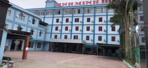 a large blue building with a palm tree in front of it at Binh Minh Dien Chau Hotel in Diễn Châu