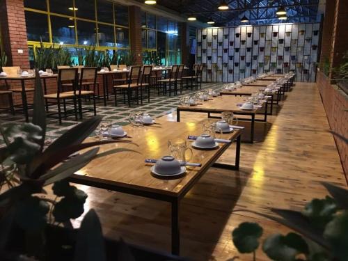 a long row of tables with plates and glasses on them at Binh Minh Dien Chau Hotel in Diễn Châu