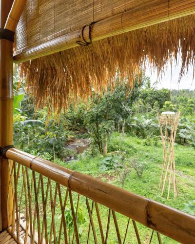 a view from a porch with a straw roof at Bamboo & B in Licin