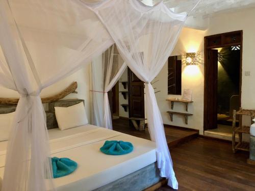 a bedroom with a bed with a canopy at Zanzistar Lodge in Jambiani