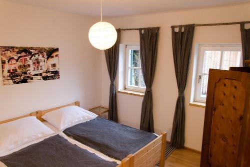 ein Schlafzimmer mit einem Bett und zwei Fenstern in der Unterkunft PinkDeer in Hallstatt