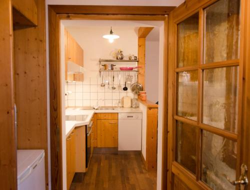 małą kuchnię z drewnianymi szafkami i zlewem w obiekcie PinkDeer w Hallstatt