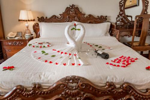 a swan decoration on a bed with a camera at Hanoi Little Town Hotel in Hanoi