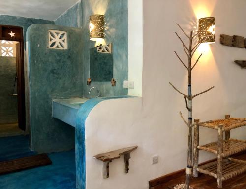 a blue and white bathroom with a sink at Zanzistar Lodge in Jambiani