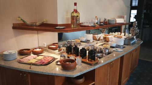 a table with a bunch of food and a bottle of wine at Hotel Gasthaus Tröster in Schmallenberg