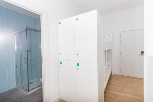 a bathroom with a glass shower and blue tiles at Ram Rooms R.C. in Tarragona