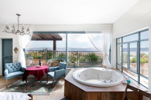 a large bathroom with a tub and a table and chairs at Point of View in Bruchim Qela' Alon
