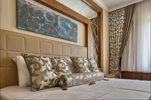 a bed with pillows and pillows on it at City Hotel Residence in Ankara