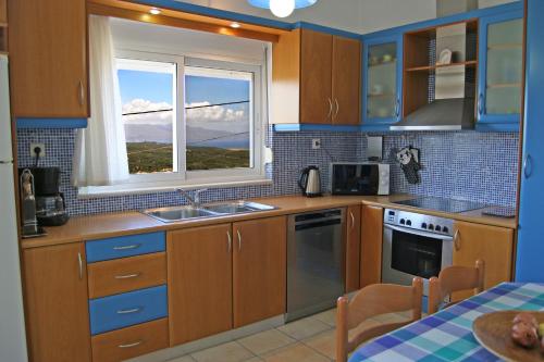 a kitchen with wooden cabinets and a sink and a window at Villa SteMa in Xirokámbion