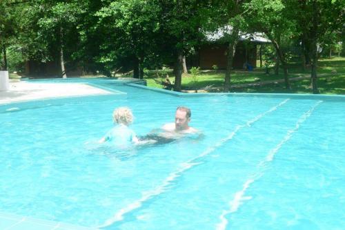a man and a woman swimming in a swimming pool at Nil Diya Mankada Safari Lodge in Udawalawe